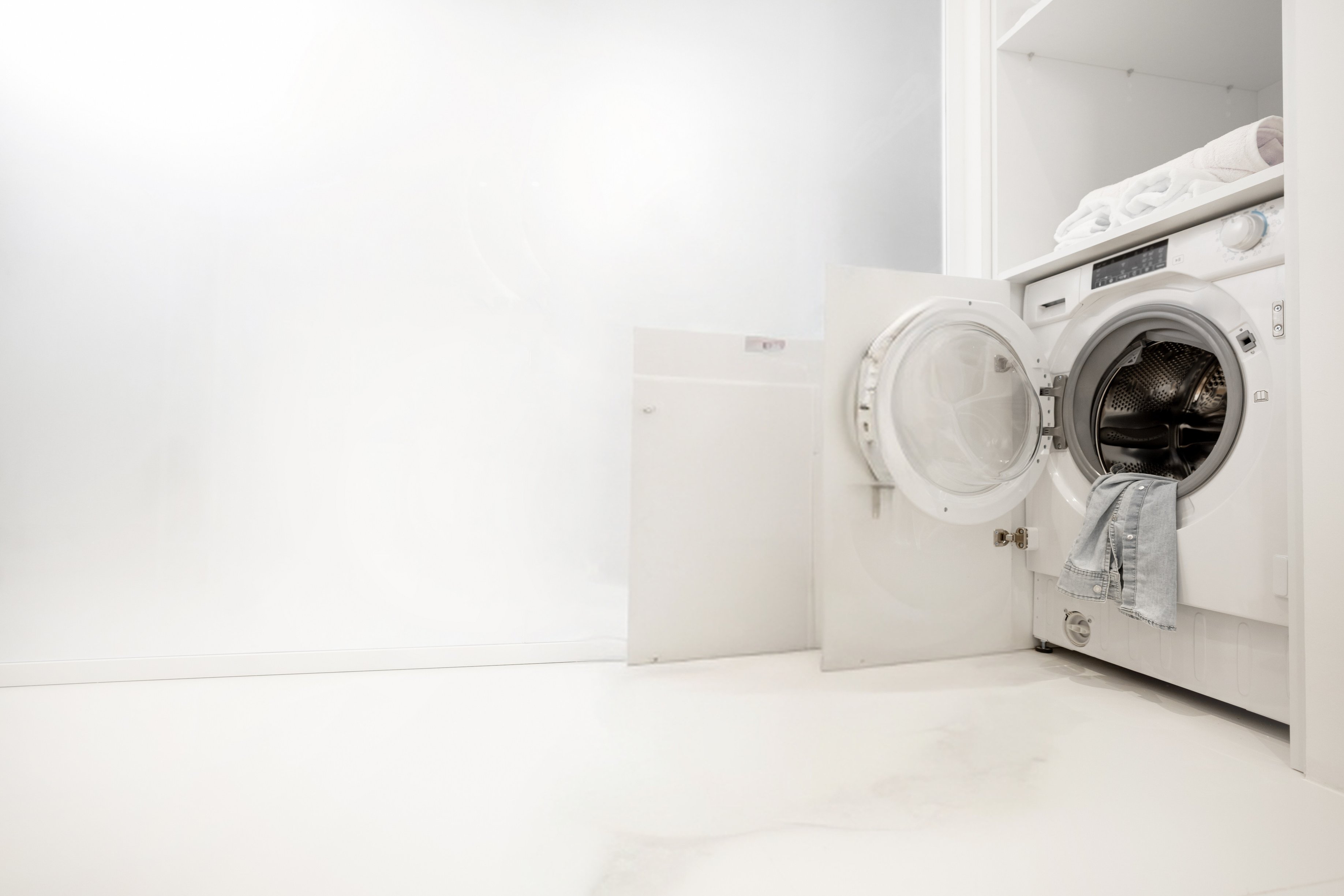 Woman Washing Clothes with Washing Machine in Bathroom